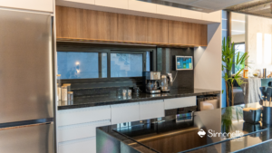 Cozinha moderna Simonetto com bancada em granito preto, armários brancos e detalhes em madeira.