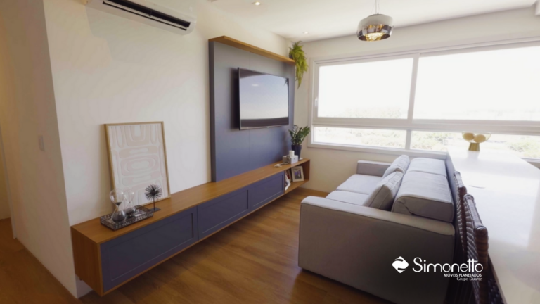 Sala de estar com móveis planejados Simonetto Grupo Duarte em acabamento amadeirado e azul grafite, incluindo painel de TV e bancada com design contemporâneo e iluminação natural.